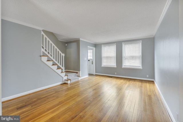 unfurnished living room featuring crown molding and light hardwood / wood-style flooring