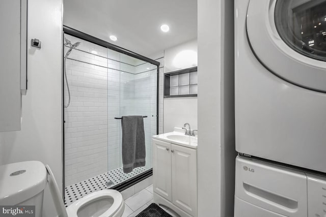 bathroom with walk in shower, stacked washer and dryer, and vanity