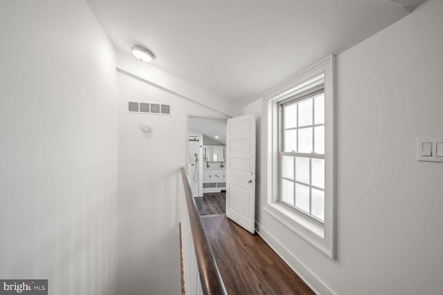 corridor featuring vaulted ceiling and dark wood-type flooring