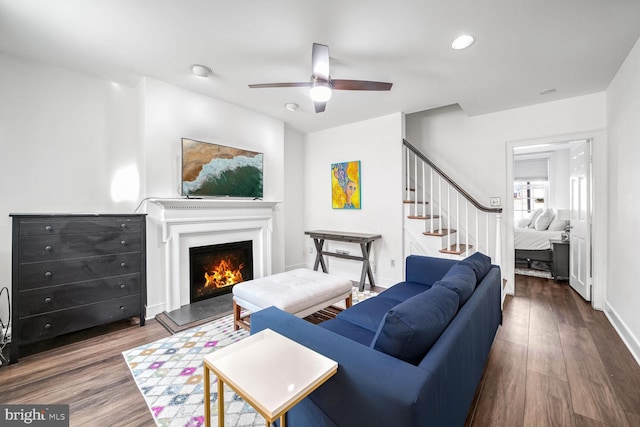 living room with ceiling fan and dark wood-type flooring