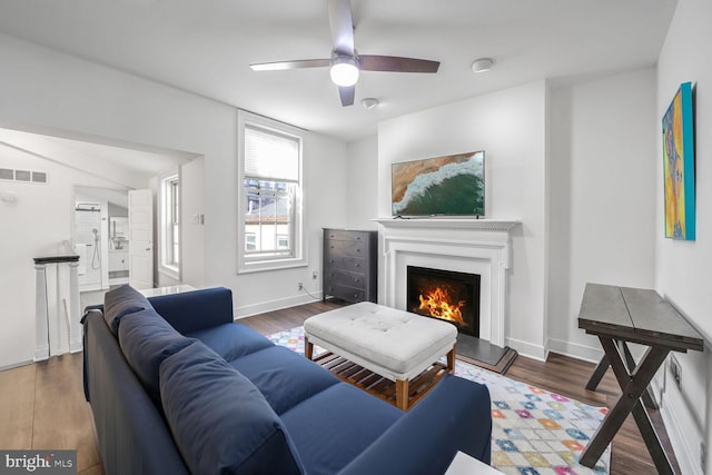 living room with ceiling fan, dark hardwood / wood-style flooring, and vaulted ceiling