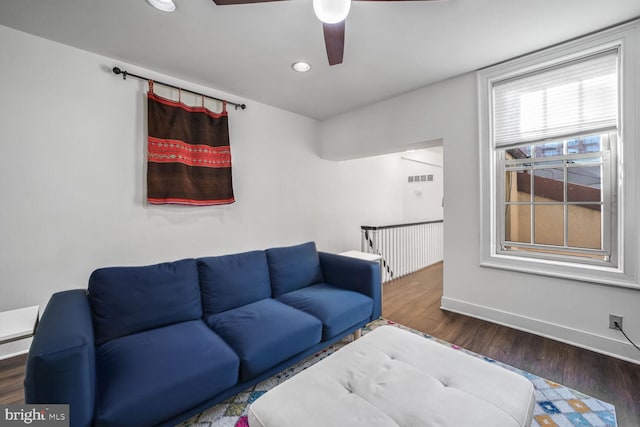 living room with dark wood-type flooring and ceiling fan