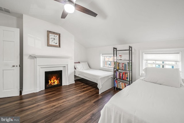 bedroom with ceiling fan, vaulted ceiling, and dark hardwood / wood-style floors