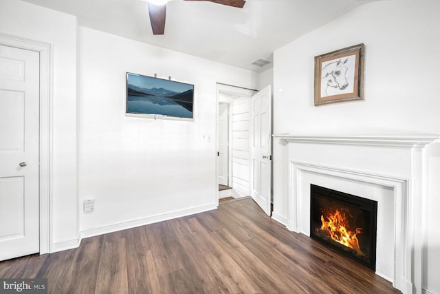 unfurnished living room featuring ceiling fan and dark wood-type flooring