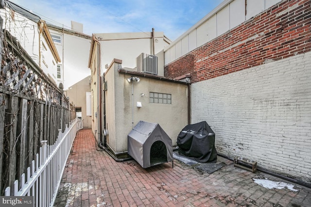 view of patio with central AC unit and a grill