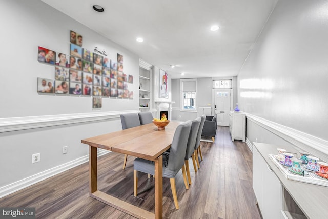 dining room featuring wood-type flooring and built in features