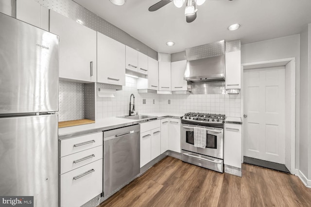 kitchen featuring sink, white cabinets, dark wood-type flooring, backsplash, and stainless steel appliances