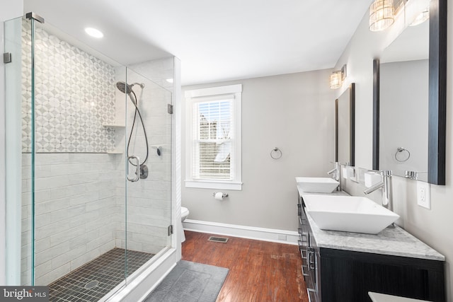 bathroom featuring vanity, an enclosed shower, hardwood / wood-style flooring, and toilet