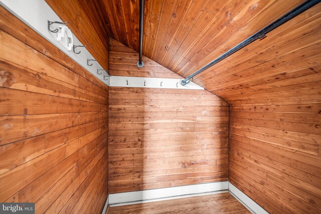 interior details with wood-type flooring, wooden walls, and wooden ceiling