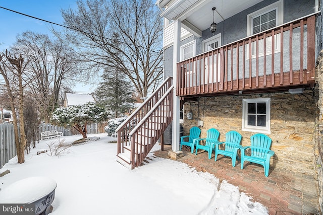 snow covered patio with a deck