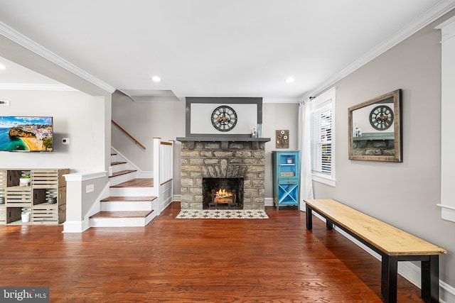 living room featuring hardwood / wood-style flooring, a fireplace, and crown molding