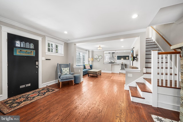 foyer entrance with hardwood / wood-style flooring and crown molding