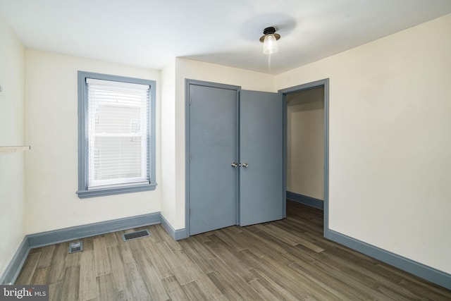 unfurnished bedroom featuring a closet and hardwood / wood-style floors