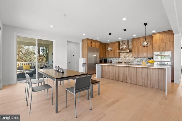 dining space with sink and light wood-type flooring