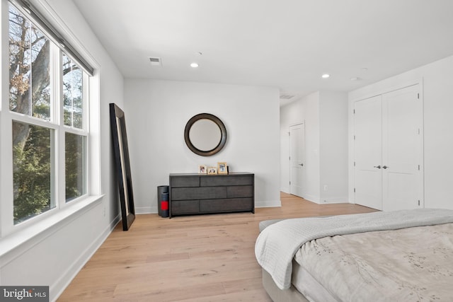 bedroom with multiple windows and light hardwood / wood-style floors