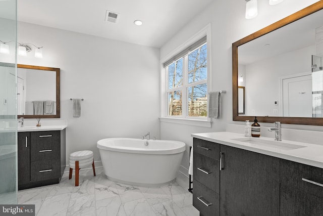 bathroom with vanity and a bath