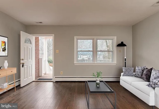 living room with a baseboard heating unit and dark hardwood / wood-style flooring