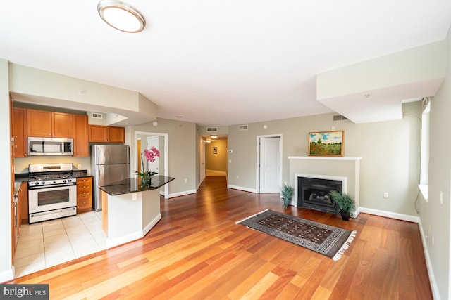 kitchen with light hardwood / wood-style floors, stainless steel appliances, and a kitchen island