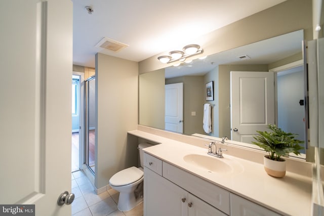 bathroom with toilet, vanity, an enclosed shower, and tile patterned flooring