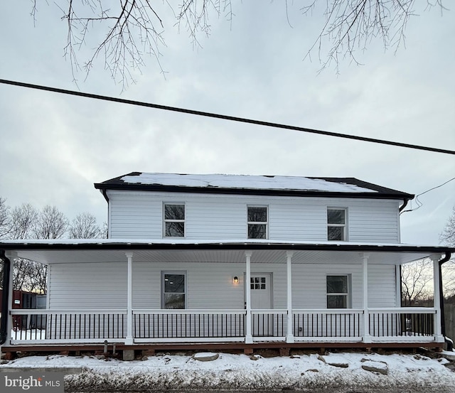 snow covered property featuring covered porch