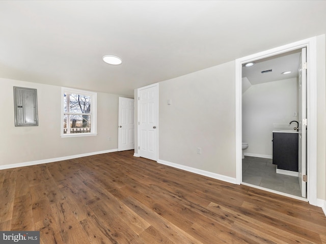 interior space featuring sink, dark hardwood / wood-style floors, connected bathroom, and electric panel