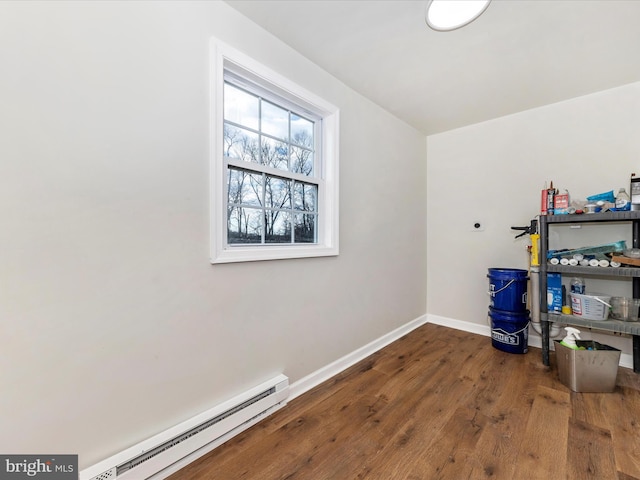 clothes washing area with wood-type flooring, hookup for an electric dryer, and baseboard heating