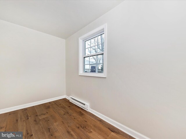 spare room with a baseboard heating unit and hardwood / wood-style floors