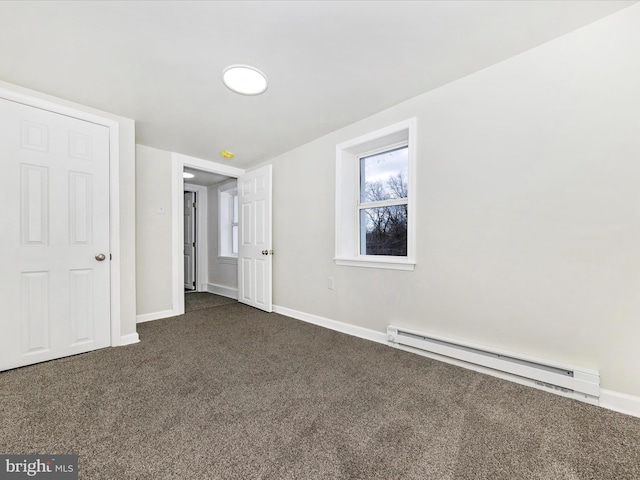 unfurnished bedroom with dark carpet and baseboard heating