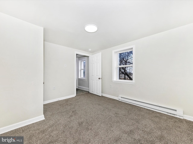 carpeted spare room with a baseboard radiator