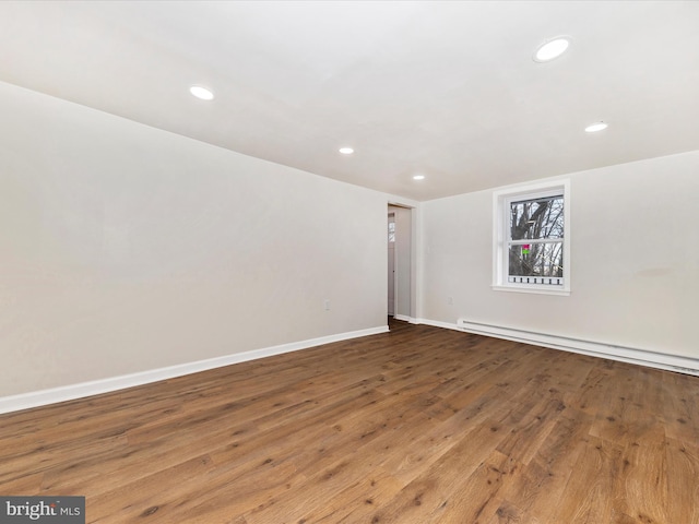 spare room featuring hardwood / wood-style flooring and baseboard heating