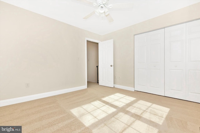 unfurnished bedroom featuring carpet floors, ceiling fan, baseboards, and a closet