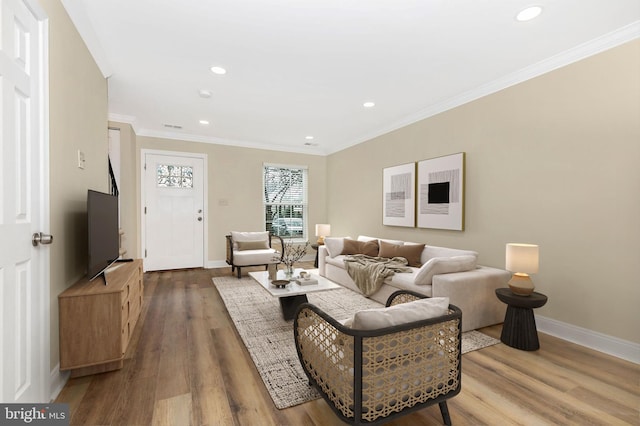 living room featuring recessed lighting, baseboards, crown molding, and wood finished floors