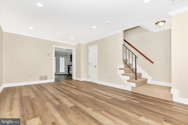 unfurnished living room with stairway, visible vents, light wood finished floors, and crown molding