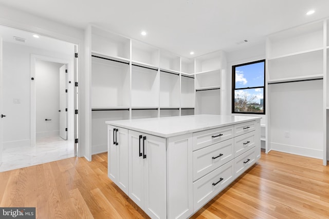 walk in closet with light hardwood / wood-style flooring