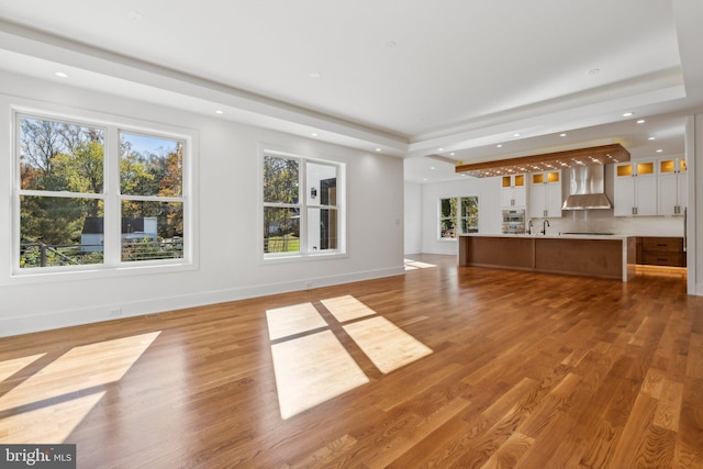 unfurnished living room featuring hardwood / wood-style flooring and sink