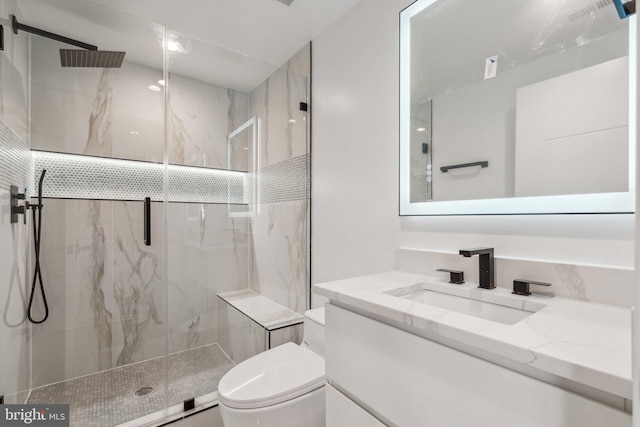 bathroom featuring vanity, toilet, and an enclosed shower