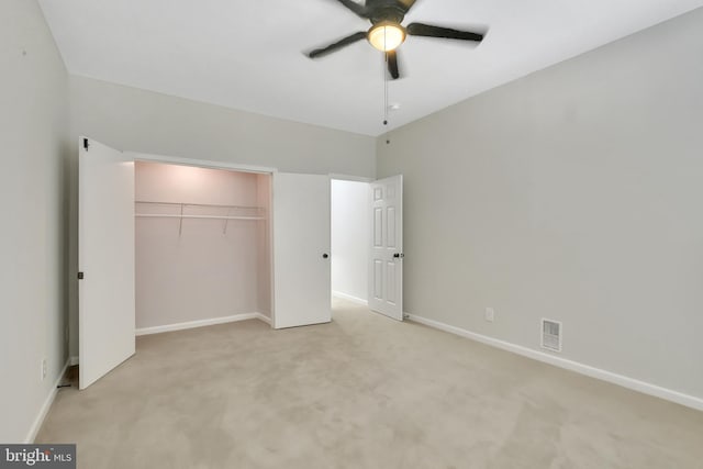 unfurnished bedroom featuring ceiling fan, a closet, and light carpet