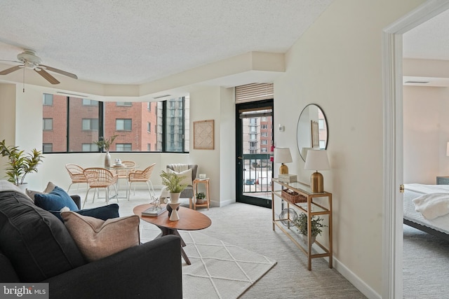 carpeted living room featuring ceiling fan and a textured ceiling