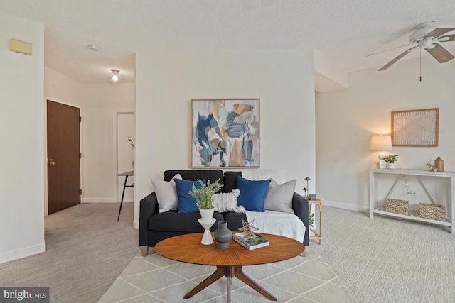 carpeted living room with ceiling fan and a textured ceiling