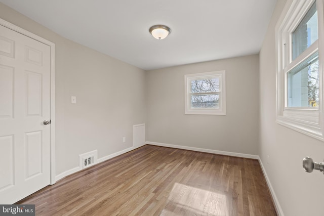 empty room featuring plenty of natural light and light hardwood / wood-style floors