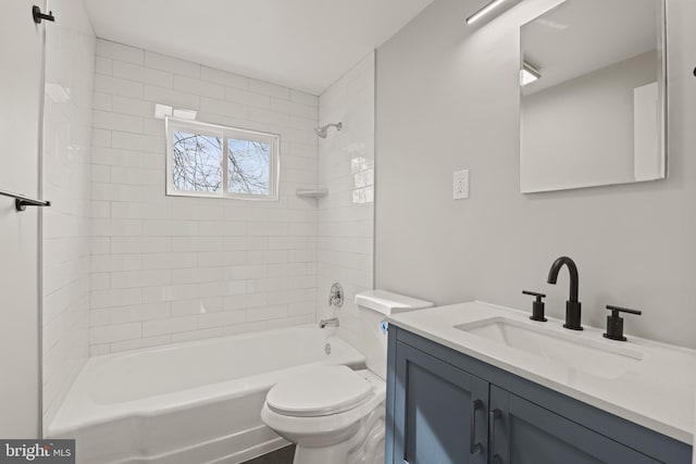 full bathroom featuring vanity, tiled shower / bath combo, and toilet