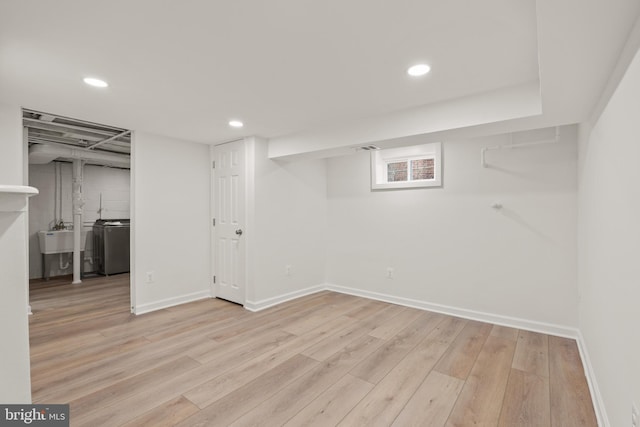 basement with sink and light hardwood / wood-style flooring