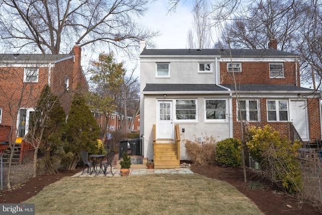 back of property with a yard and a patio