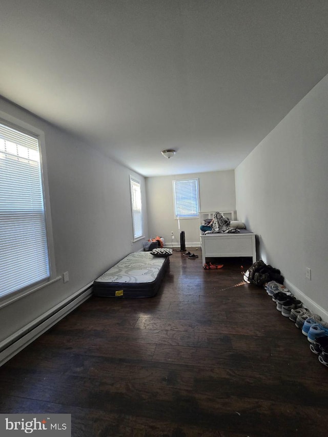 unfurnished bedroom featuring a baseboard radiator and dark hardwood / wood-style floors