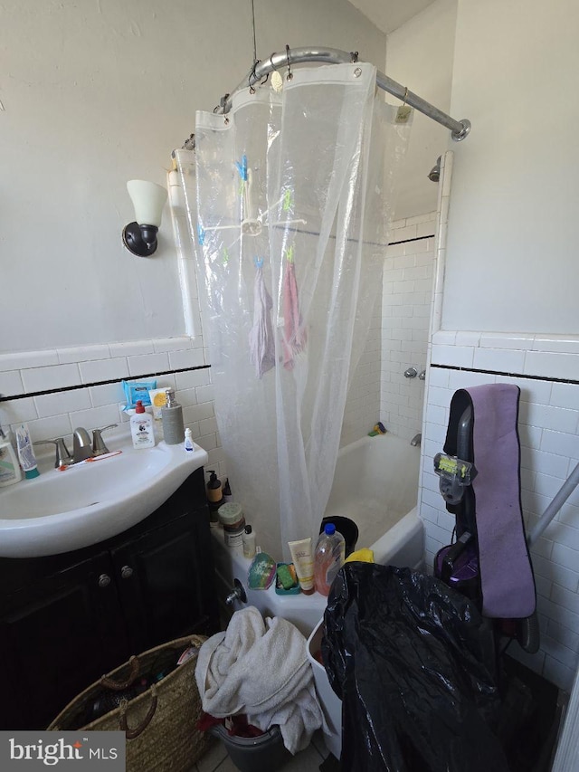 bathroom with vanity, shower / bathtub combination with curtain, and tile walls