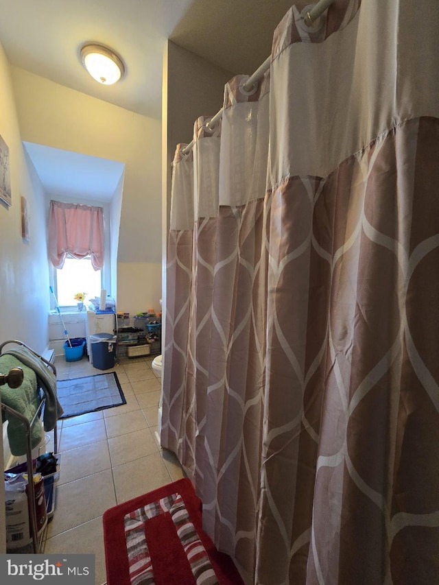 bathroom featuring toilet, tile patterned floors, and a shower with shower curtain