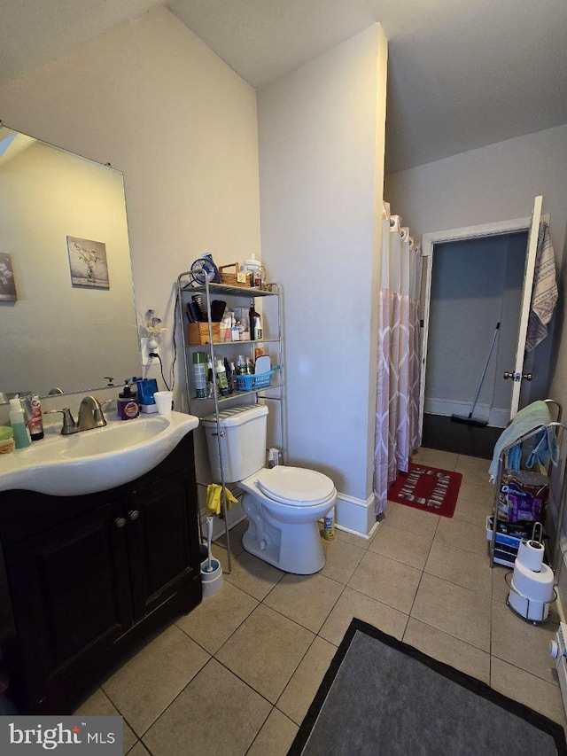 bathroom with walk in shower, lofted ceiling, toilet, vanity, and tile patterned flooring