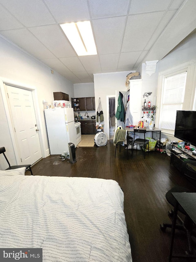 bedroom featuring sink, a paneled ceiling, wood-type flooring, and white fridge