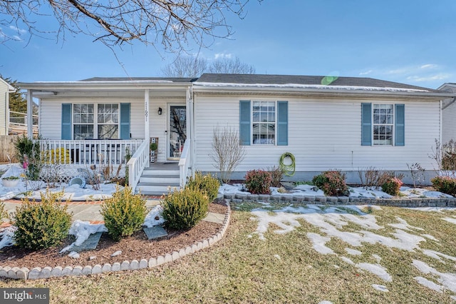 ranch-style home featuring a porch and a front lawn