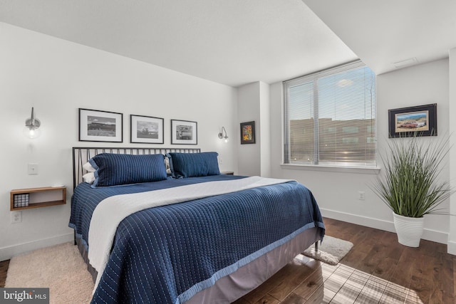 bedroom with baseboards and wood finished floors